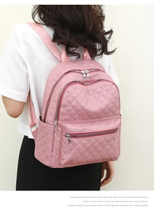 Detalle del patrón de rombos acolchados y textura de nailon impermeable en la mochila rosa
