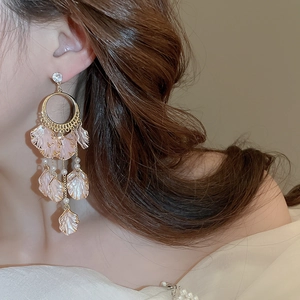 Detail showing pink petal tassel earrings with pearls on a model for a graceful look