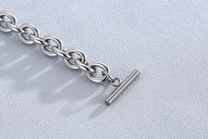 Macro shot of silver stainless steel O-chain bracelet with polished OT toggle clasp detail