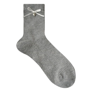 Gray knitted crew socks with white bows and heart metal pendants on a white background