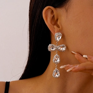 Close-up of model wearing silver teardrop tassel earrings with sparkling rhinestones