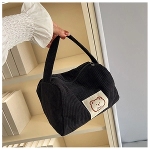 Close-up of black corduroy mini tote bag with a cute cartoon bear patch on the front