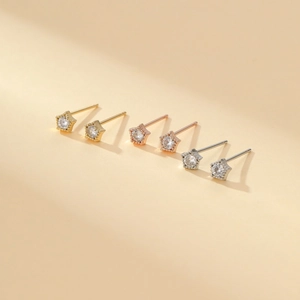 Detail showing gold, rose gold, and silver star stud earrings with zircon inlay