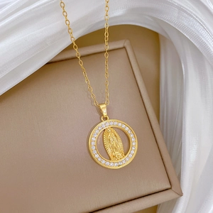 Macro shot of gold pendant with religious portrait and crystals on silk background