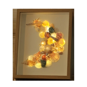 Handmade wooden frame night light featuring a crescent moon made of sea shells and pearls