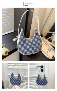 Detail of white denim crescent bag with blue checkerboard pattern and frayed fringe trim
