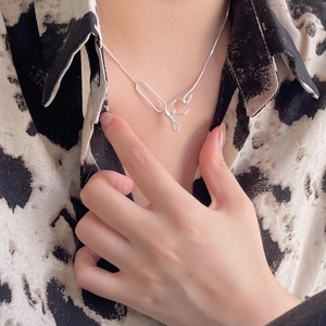 Close-up of minimalist 925 sterling silver geometric pendant necklace on model