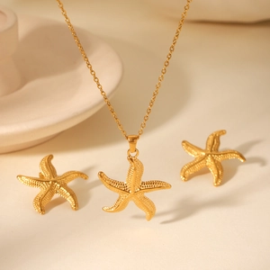 Détail d'un ensemble collier et boucles d'oreilles étoile de mer dorée avec texture