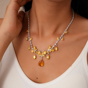 Close-up of vintage butterfly drop necklace with yellow gems on woman's neck