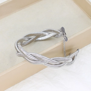 Macro shot of silver triple-strand twisted snake chain choker on textured background