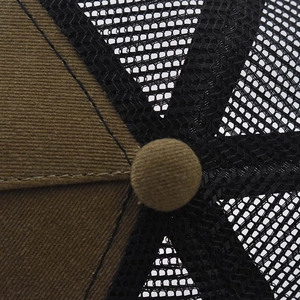Detail of the trucker hat crown with brown twill fabric and breathable black mesh stitching