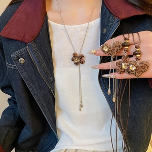 Detail of leopard print heart and flower pendants with crystals on a dark cord necklace