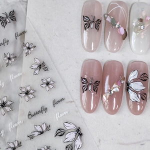 Stickers à ongles papillon et fleur avec motifs de lignes noires sur ongles rose nu