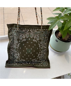 Detail of paisley printed tote bag in olive green with colorful braided rope handle