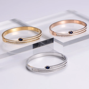 Three snake bracelets in gold, silver, rose gold with cubic zirconia and blue stones