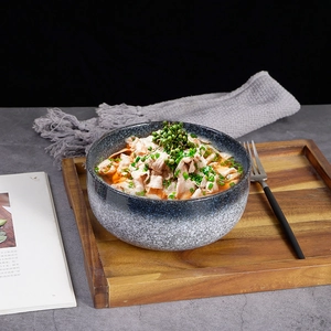 Japanese ceramic soup bowl with blue and white snowflake glaze on a wooden tray