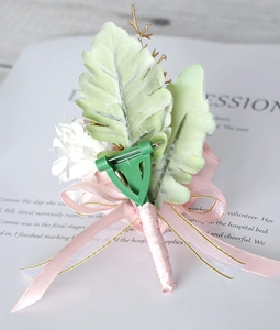 Detail view of pink PE rose boutonniere showing the back pin and satin ribbon texture