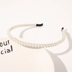 Close-up of slim pearl headband featuring multi-row white pearls on a display stand