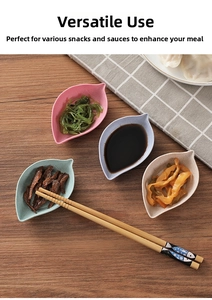 Leaf-shaped wheat straw sauce dishes in four colors on a wooden table with plaid cloth
