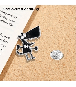Detailed size view of cartoon wolf enamel brooch measuring 2.2cm x 2.5cm on cork surface
