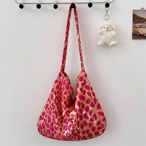 Detail of a large canvas tote bag featuring vibrant pink and orange leopard print patterns