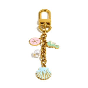 Porte-clés plaqué or 18 carats avec sable dollar, hippocampe, perle et coquillage bleu