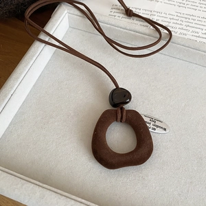 Detailed view of vintage flocking resin pendant with dark brown velvet texture necklace