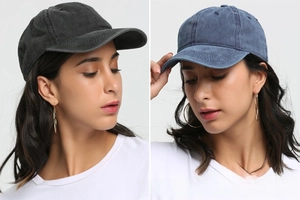Detail view of washed cotton baseball caps in black and blue with curved brims