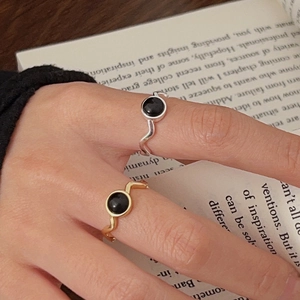 Close-up of gold and silver 925 sterling silver rings with black agate on hands