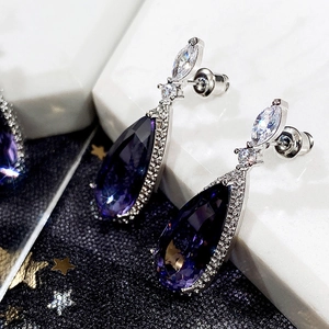 Gros plan de boucles d'oreilles goutte en argent avec cristaux violets et zircons