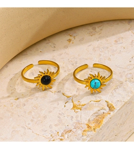 Macro detail of gold-plated sun rings featuring obsidian and turquoise stone inlays
