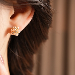 Gros plan sur des boucles d'oreilles en perles et strass sur une base en métal doré