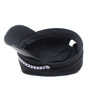 Detailed view of the black newsboy cap interior and glossy leather brim with silver chain