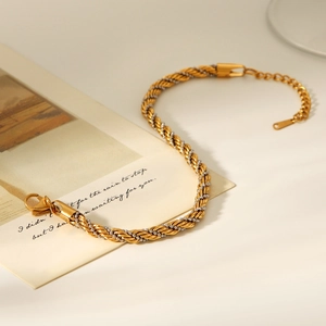 Détail de la chaîne de cheville torsadée bicolore avec fermoir mousqueton sur fond blanc