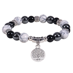 Détail de perles en pierre de marbre noir mat et blanc avec un pendentif Arbre de Vie