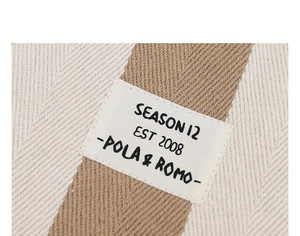 Detailed view of striped canvas texture and embroidered SEASON 12 brand label