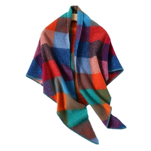Colorful plaid cashmere-like scarf with fringe edges hanging on a wooden hanger