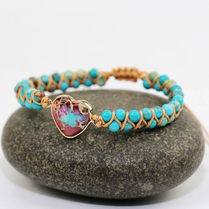 Bohemian braided turquoise bead bracelet with gold-edged heart stone on pebble