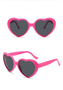 Detailed views of peach pink heart-shaped sunglasses with dark grey lenses in 45-degree angle