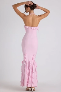 Détail du dos nu élégant et de l'ourlet à volants de la robe de soirée longue rose