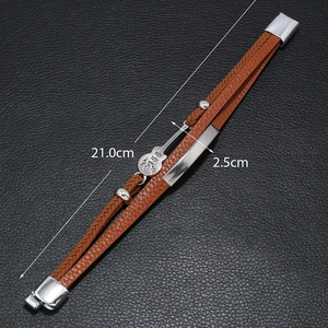Detailed view of men's brown braided leather bracelet with guitar charm and 21cm size mark