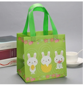 Detail of eco-friendly green Easter gift bag with white rabbits and sturdy square base