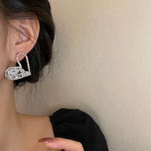 Elegant silver hollow heart earrings with sparkling cubic zirconia on female model