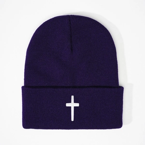 Detailed texture of dark purple knitted beanie with white cross embroidery