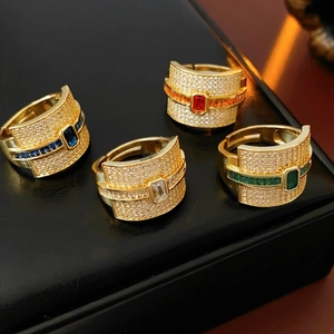 Detailed shot of gold plated hip hop rings with colorful rectangular crystals and pavé stones