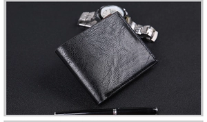 Detailed view of black leather wallet with stitching detail, watch and pen business set
