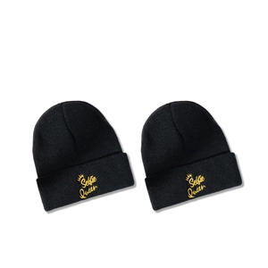 Pair of black knit beanies featuring golden Selfie Queen embroidery and crown icon