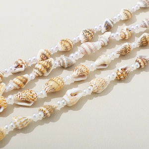 Vintage beach style necklace with natural conch shells and white pearls on beige leather