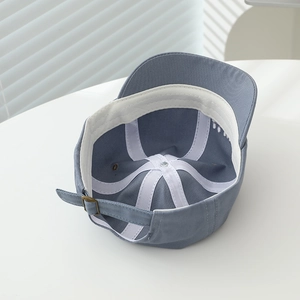 Detailed interior of infant baseball cap showing cotton twill, sweatband and metal buckle