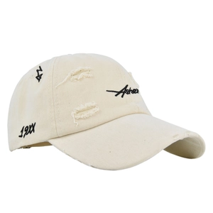 Detailed macro view of vintage distressed beige baseball cap with black Asher embroidery